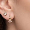 Moonstone stud worn in a second lobe piercing above a gold hoop with a pale gemstone drop.