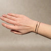 GOLDEN pyrite and 9k gold accents bracelet worn on the wrist alongside another beaded bracelet.