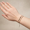 OLIVE semi-precious bead bracelet with 9k gold accents, worn alongside a pavé bar bracelet