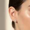 Gold hamsa earrings on model
